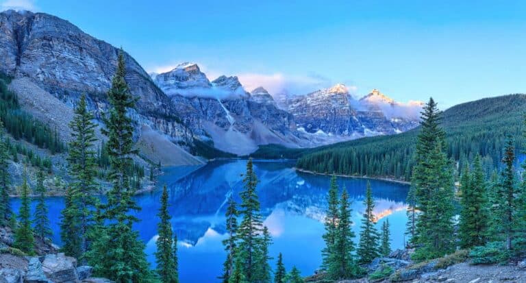 Schöner Bergsee in den kanadischen Rocky Mountains, umgeben von Tannenwäldern und hohen Gipfeln, perfekte Kulisse für Natur- und Outdoor-Seminare.