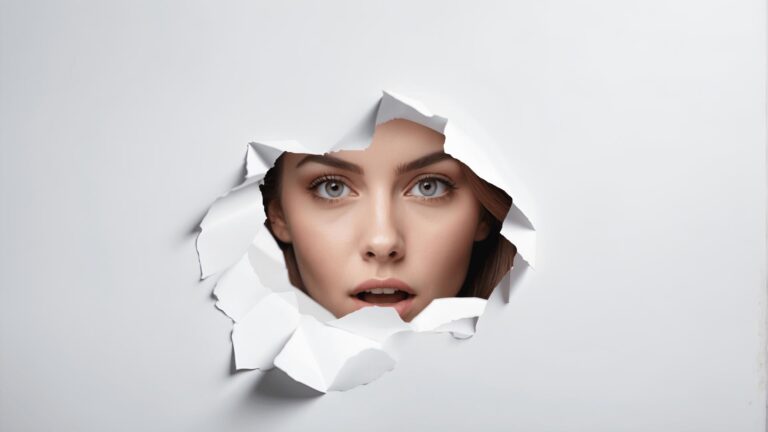 Durchbruch im Design: Frauenportrait mit überraschendem Blick durch zerbrochenes Weißpapier – Kreativität und Innovation in der Mediengestaltung.