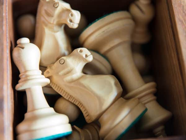 Schachfiguren aus Holz in einer Schublade, symbolisieren Strategie und Planung für Business- und Coachingservices bei Slamanig Consulting & Training.