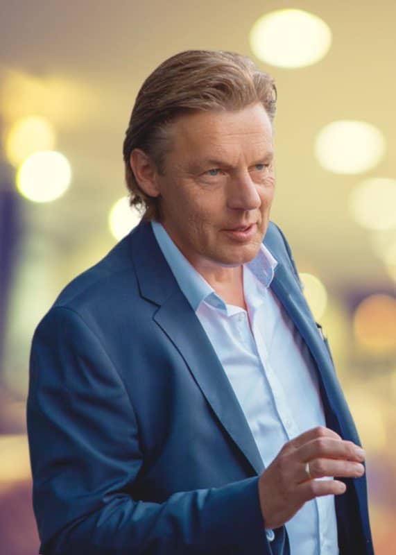 Berater im Business-Outfit vor begeistertem Publikum, Business-Coaching und Training, kompetente Führungskräfteentwicklung, Erfolg im Beruf.