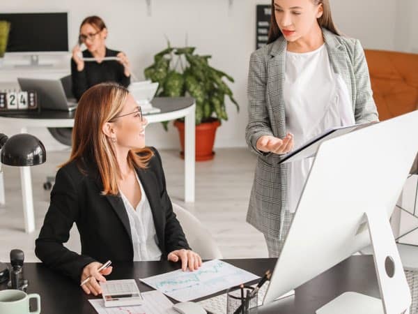 Moderne Businessberatung im Büro, Frauen im Gespräch, Fokus auf professionelles Training und Beratung bei Slamanig Consulting & Training.