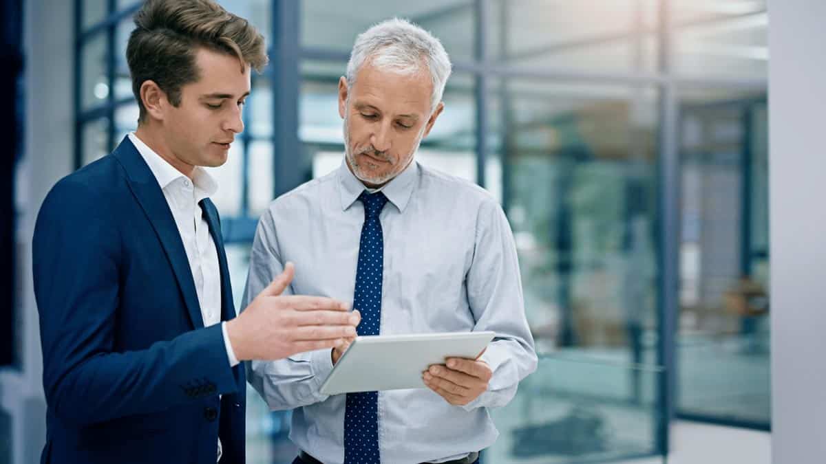Ingenieur und Manager im Gespräch vor moderner Unternehmensfassade, Digitalisierungsstrategie, Business-Meeting, Beratung, Zusammenarbeit, Innovation.